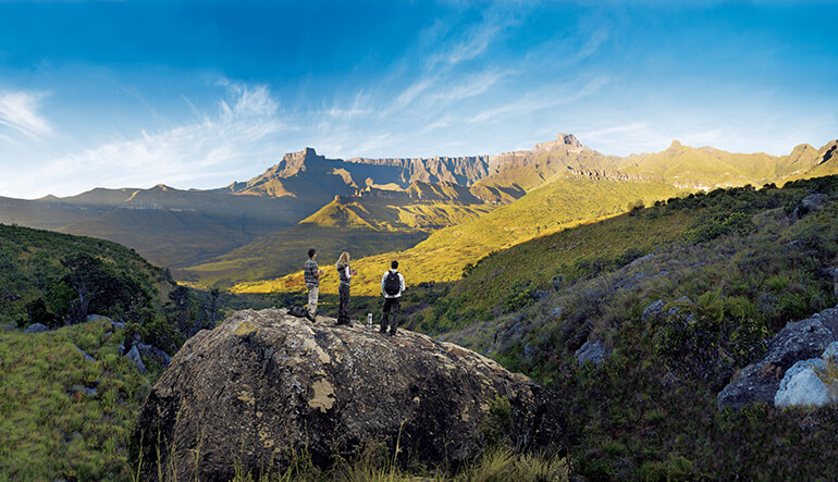 Three hikers enjoying sunrise in the Drakensberg