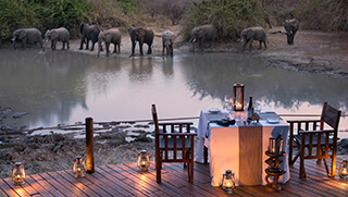Dining deck of andBeyond Kanga Camp with elephant across river 