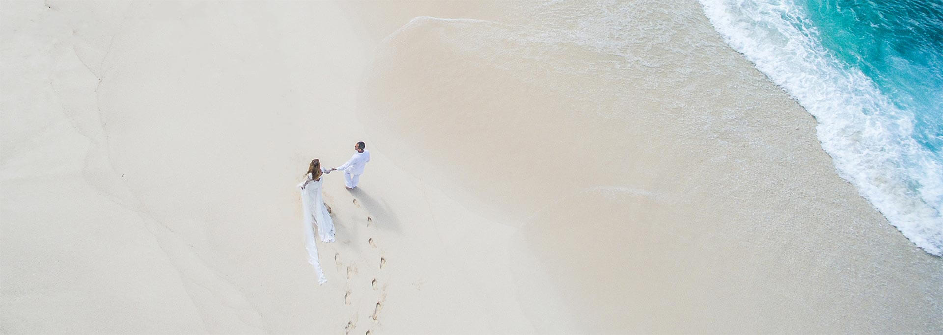 Couple walking on the beach in North Island Seychelles