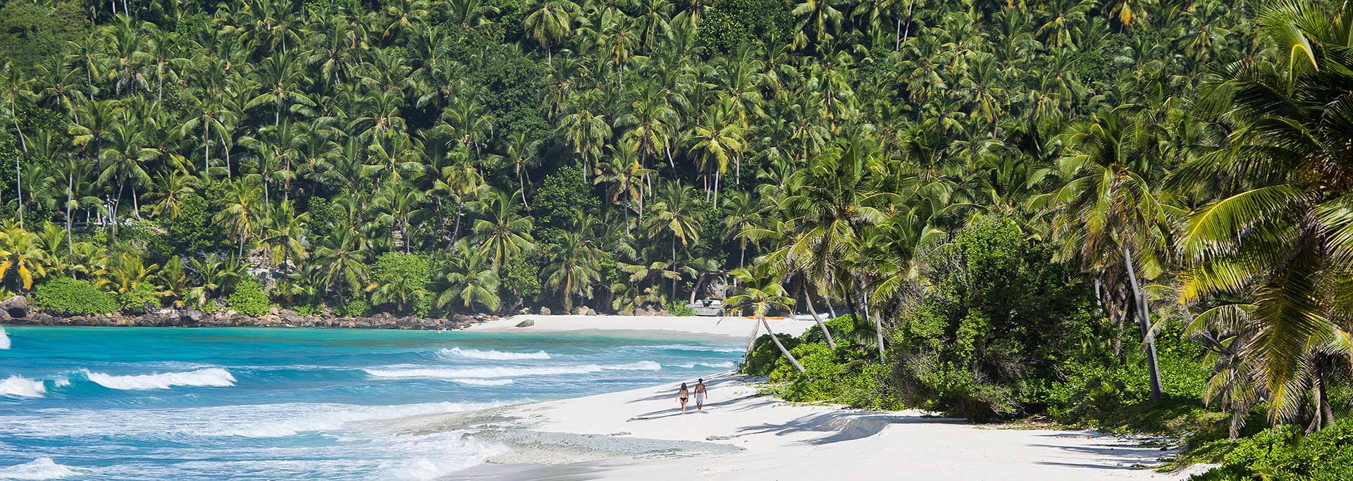 Couple walking on the beach in North Island, Seychelles