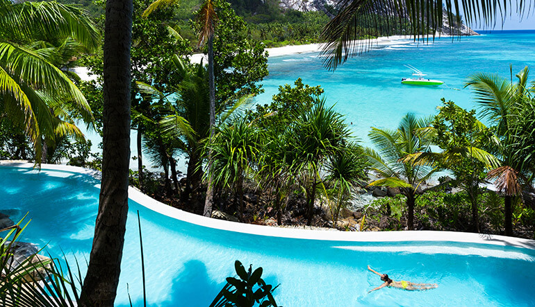 Woman swimming in the pool at North Island Seychelles