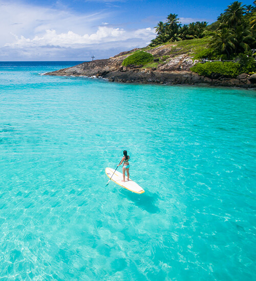 Woman stand up paddle boarding in Seychelles