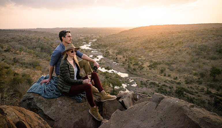 Couple enjoying romantic sunset in the Kruger National Park