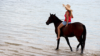 Woman horseback riding on the beach at Benguerra Island