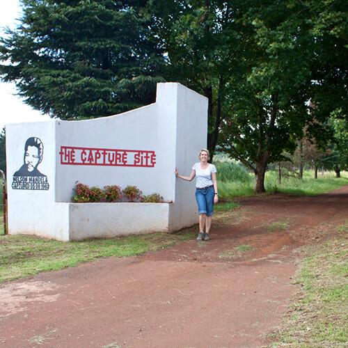 Woman standing outside the entrance to the Nelson Mandela Capture Site