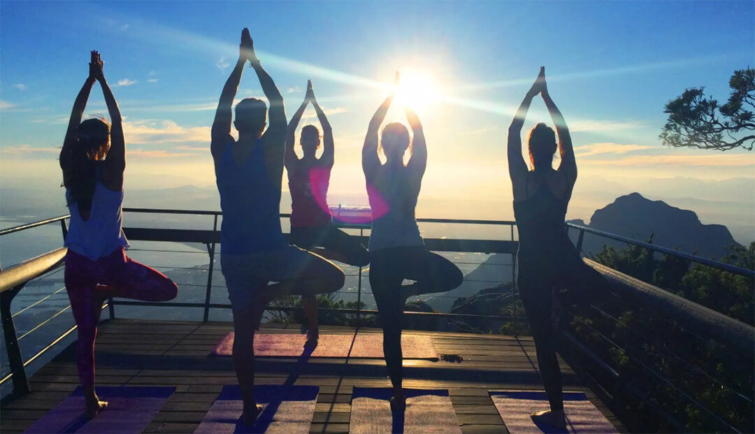 Sun salutation yoga on Table Mountain at sunrise