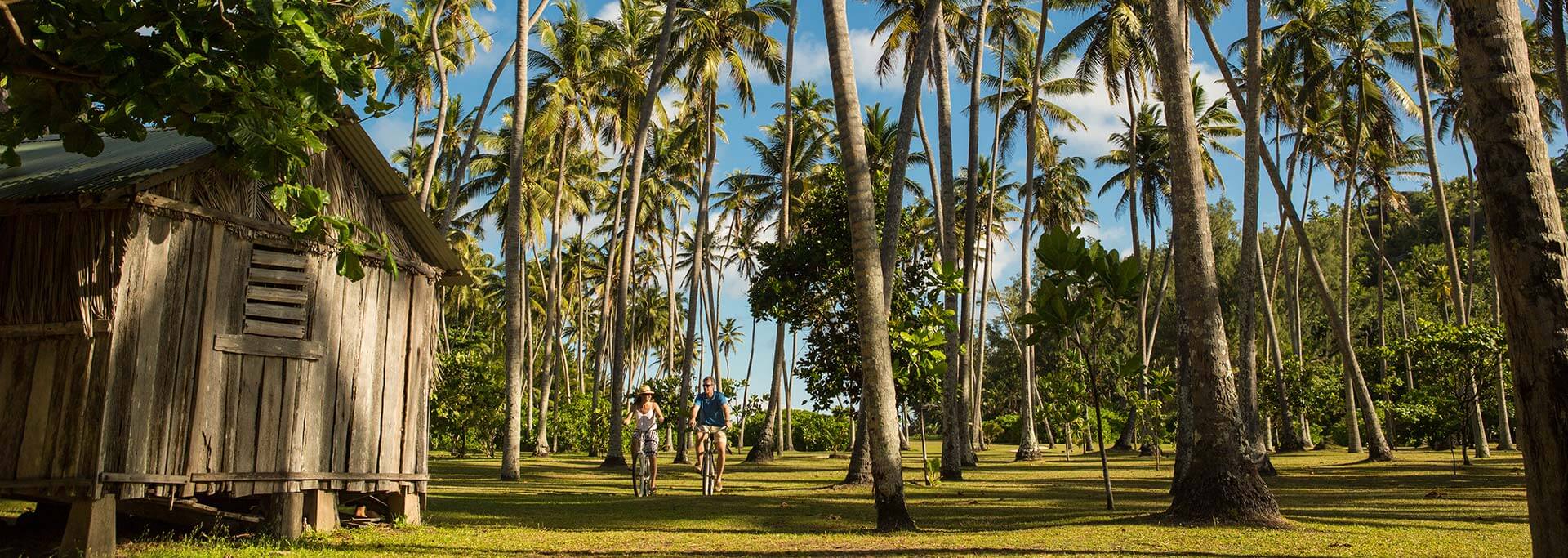 Couple cycling through jungle at North Island Seychelles