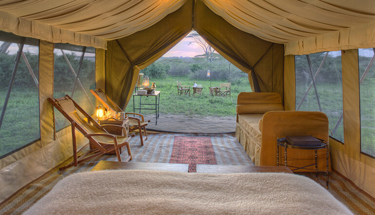 Inside the luxury tent at Luxury tented suite at andBeyond Serengeti Under Canvas at night