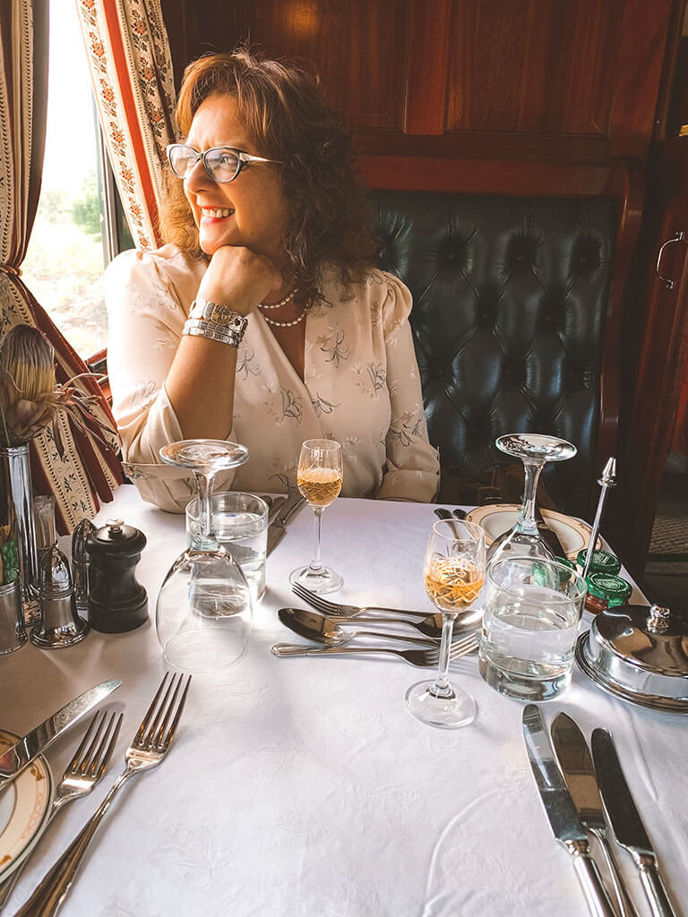 Woman staring out of window of Rovos Rail Dining Cart