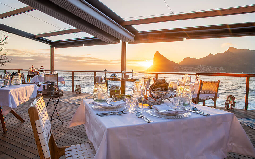 Outdoor dining at sunset on the deck at Tintswalo Atlantic