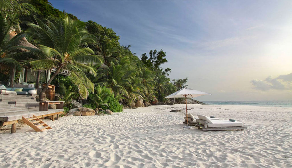Beach loungers and sea sand at North Island on the Seychelles