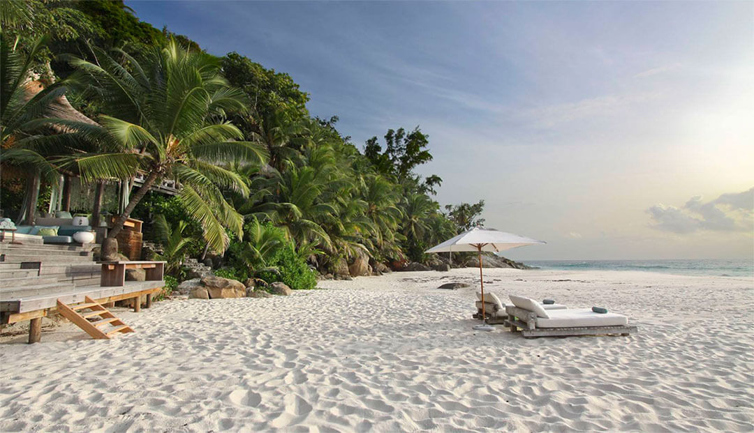 Beach loungers and sea sand at North Island on the Seychelles