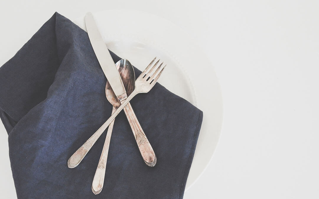 Fork, knife and spoon with dark blue napkin