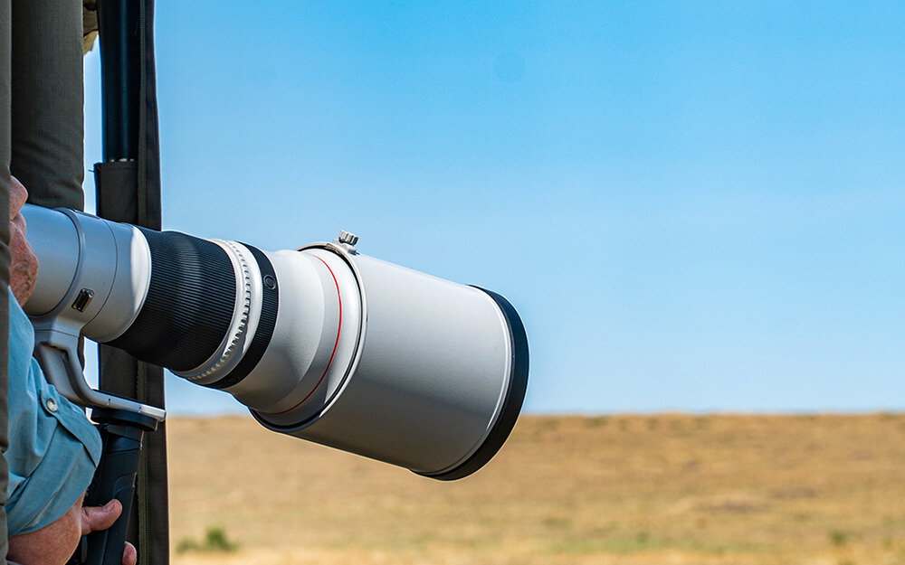 Large camera lens used during wildlife photographic safari in Africa